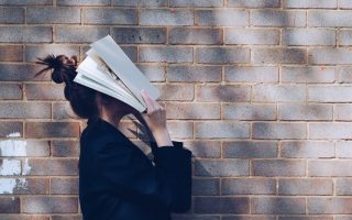 Woman covering her face with a book