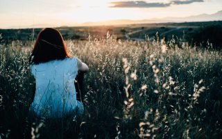 Woman sitting alone in a field